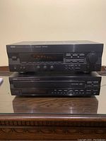 Front view of Yamaha Natural Sound stereo receiver on top and CD player below, both black with digital displays and multiple buttons