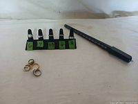 Rings displayed on black finger stand with size markers 6, 7, 6.5, 6, and 9, accompanied by loose rings and a ring sizer tool nearby.