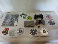 Full lot overview showing the PlayStation console, controllers, many game discs, and Game Informer magazine