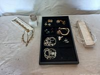 Full view of assorted jewelry laid out with some in original cases showing various styles and metals.