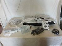 Photo showing Lenovo monitor wrapped in protective material along with power cable and documentation on table.