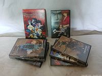 View of all 8 Anime DVDs showing the bundle including the Record of Lodoss War box set, Samurai X DVD, and stacked Planzet DVDs.