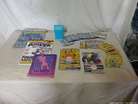 Wide shot of assorted Pokémon cards spread on a table with card sleeves, guidebooks, and magazines.