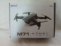 Front side of drone box showing the M71 model and drone image, 4K optical flow, double camera, and gesture photo features.