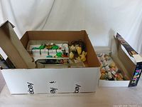 Box containing multiple loose vintage party lights and packaging materials showing various light covers including animals and palm trees.