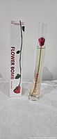 Photo of Flowerbomb perfume bottle next to its box, showing brand name and rose design