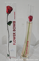 Photo displays the Flowerbomb perfume bottle with a red rose inside and the original packaging box showing a rose illustration and product name.