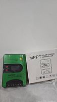 Green Tracer Dream Series MPPT solar charge controller with label and manual beside it.