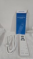 White Dewenwils power saving strip timer with multiple outlets and a white cord, shown with its blue and white box.