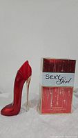 Photo showing the red high heel shaped perfume bottle next to its box with Sexy Girl branding.