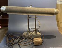 Side view of the banker lamp showing cylindrical shade and weighted base.