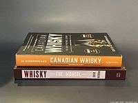 Two whiskey books stacked with titles clearly readable on the spines.