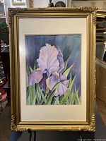 Front view of the framed painting showing the iris flower artwork with signature, surrounded by a gold ornate frame.
