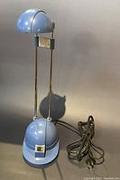 Front view of the small adjustable blue tabletop lamp with power cord extended and switch visible on base.