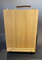 Closed wooden tabletop easel showing front panel with ledge for canvas.