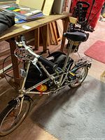 Full view of silver Dahon folding bike with frame unfolded, black carry bag mounted