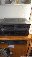 Stacked shot showing Technics receiver on top and JVC CD player below on wooden shelf.