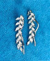 Front view of sterling silver olive leaf earrings showing detailed leaf-shaped stones and shiny finish.