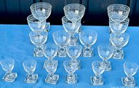 Photo showing the full set of 20 antique liquor glasses arranged in rows by size on a blue cloth background.