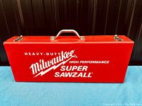 Closed red metal carrying case for Milwaukee Super Sawzall with white logo and text.