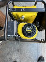 Top view showing the 196cc Champion engine with pull start and air filter cover on black frame and yellow body.