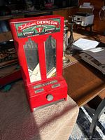 Front view showing the red gum machine with mirrored windows and lettering.