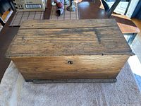 Rectangular wooden box shown from top view displaying wood grain and surface wear.