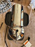 Top view showing chrome reflective dome with Nespresso branding and lever.