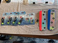 Photo showing five Scnty Power Grip Plus release clips in packaging and three loose clips and connectors arranged next to two large reflective flashers on a table.