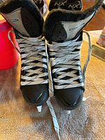 Front view of both ice skates showing white laces and tongue with WinnWell branding.