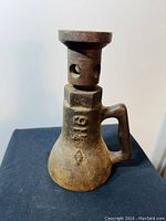 Front view of antique cast iron screw jack showing body and handle with number 101 stamped on it.