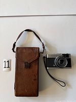 Vintage Kodak camera leather case with strap and Olympus Trip 35 camera next to it