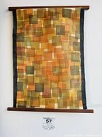 Full view of mid-century modern abstract printed linen textile with teak wood frame hung on wall.