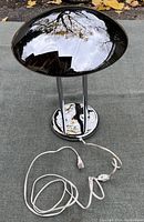 Full view of chrome mushroom lamp showing dome shade, support columns, round base, and attached power cord.