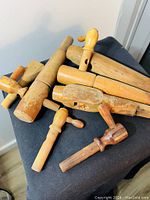 Vintage primitive wooden barrel keg valve spigots and taps piled together on a black cloth, showing various shapes and wear.