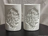 Front view of matching pair showing abstract relief design