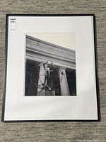 Framed photograph showing the Monument of Multiculturalism sculpture outside Toronto's Union Station with building columns and signage in background.