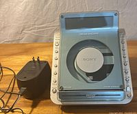 Front view of Sony Dream Machine clock radio with CD player, showing control buttons and power adapter attached