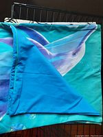 Dolphin printed cushion cover showcasing smooth polyester fabric with blue and teal colors and underwater theme.