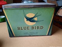 Front side of the Blue Bird toffee roll tin displaying the bird graphic and text on a green background.