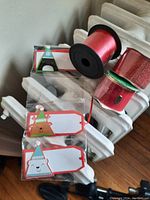 Photo of Christmas gift tags with cartoon festive designs and red curling and glitter ribbons