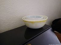 Photo of five nested Pyrex bowls with yellow marbled largest bowl at the bottom.