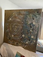 Front view of large square canvas showing spiral, star, and swirl abstract painting in earth tones and blues.