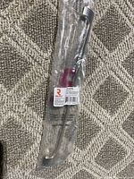 Clear plastic packaging shows a polished nickel finish pull handle with a curved design and rounded edges.