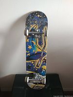 Front view of skateboard showing colorful wizard hat graphic with stars on deck.