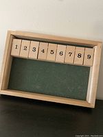 Frontal view of the wooden number blocks arranged in the tray, showing numbers 1 through 9 on natural wood blocks over green felt.