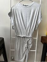 Full view of the light gray Buffalo David Bitton dress hanging on a hanger showing the cinched waist and shape