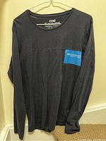 Navy blue long sleeve Jack & Jones shirt hanging, showing full front view.
