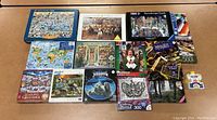 Top view of the 14 assorted puzzles and puzzle glue, showing various puzzle box artworks and titles.