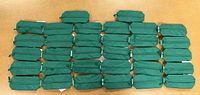 Top view of 32 green belt bags arranged in rows, showing uniform appearance and zippers.